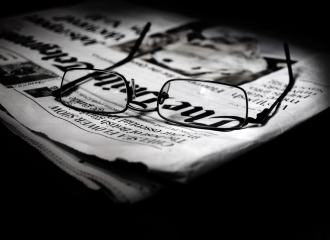 A pair of glasses on a newspaper
