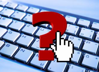 Question mark over a computer keyboard with a mouse curser over the question mark