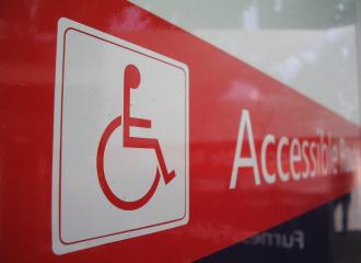 Red sign with wheelchair symbol and accessible route text